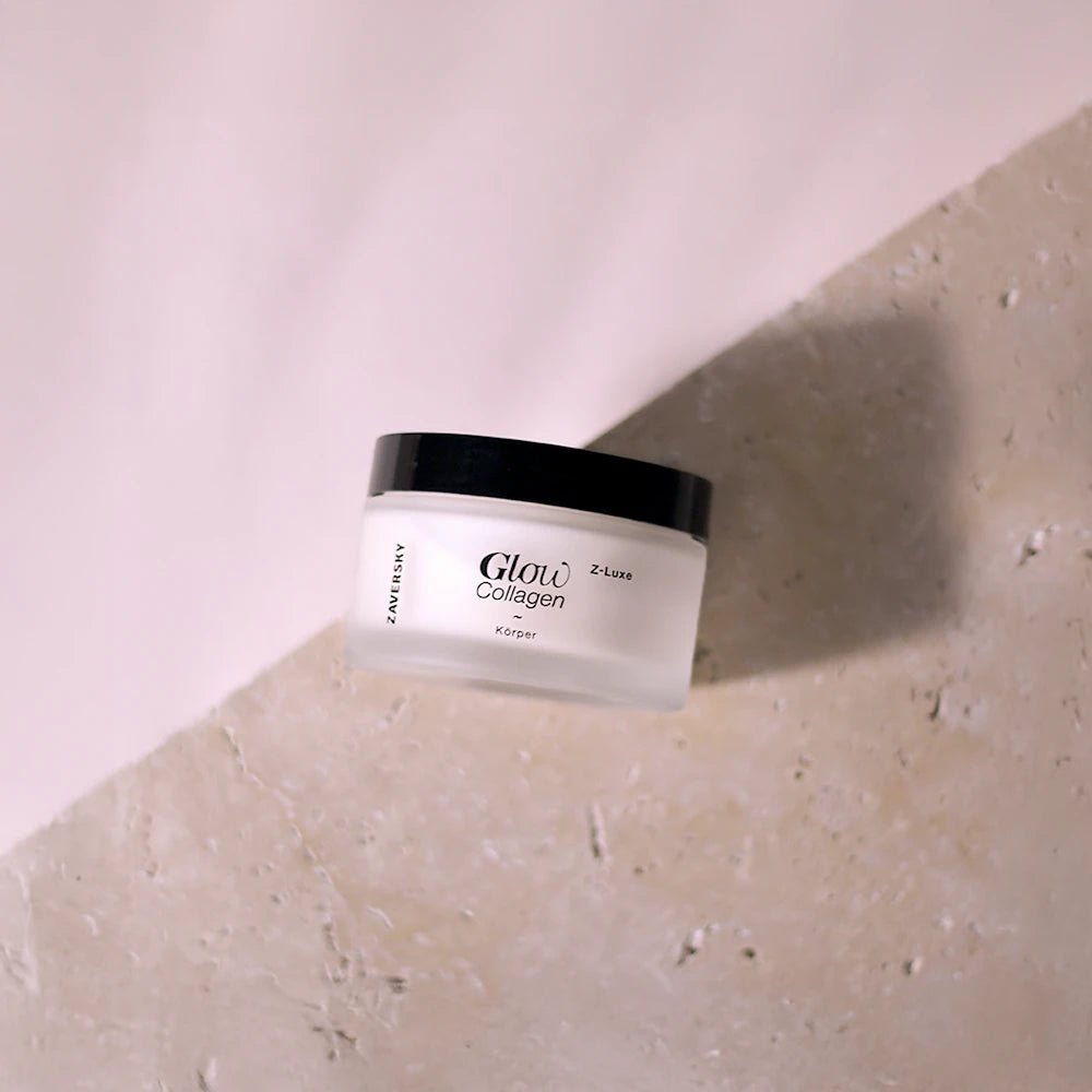 Zaversky Glow Collagen Z-Luxe Körpercreme im milchig-weißen Tiegel mit schwarzem Deckel auf hellem Steinuntergrund