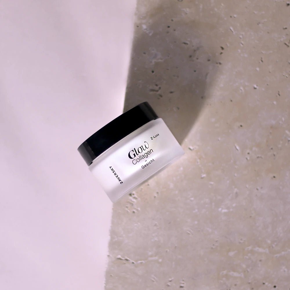 Zaversky Z-Luxe Glow Collagen Gesichtscreme im milchig-weißen Glastiegel mit schwarzem Deckel auf hellem Steinuntergru