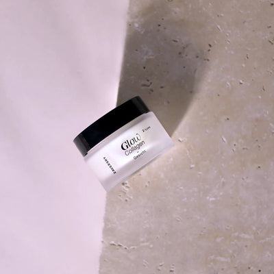 Zaversky Z-Luxe Glow Collagen Gesichtscreme im milchig-weißen Glastiegel mit schwarzem Deckel auf hellem Steinuntergru