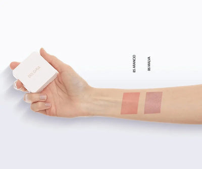 Hand hält weiße Dolomia Rouge-Dose neben Unterarm mit zwei Farbswatches 85 Arancio in Orange und 86 Malva in Rosé