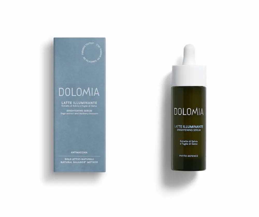 Dolomia Latte Illuminante Brightening Serum in dunkler Tropfflasche mit weißer Pipette neben hellblauer Verpackung, Vorderansicht