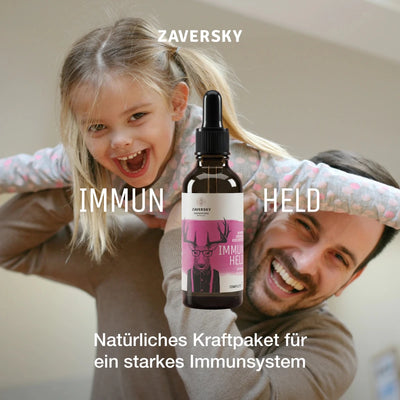 Zaversky Immun Held Tropfenflasche aus Braunglas mit pinkem Hirsch-Etikett vor lachendem Kind und Mann als Stimmungsbild