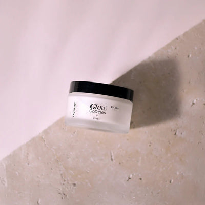 Zaversky Glow Collagen Z-Luxe Körpercreme im milchig-weißen Tiegel mit schwarzem Deckel auf hellem Steinuntergrund